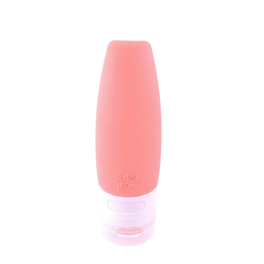 60ml Coral Pink Silicone Leakproof Travel Squeeze Bottle with Clear Ribbed Screw Cap on white background